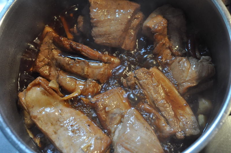 豚ばら肉を炒めて鍋に敷き詰めます