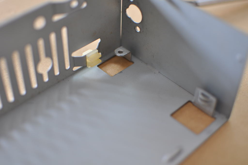 電源基板をはさみこんで固定している樹脂部品と電源ボックスの金属部分