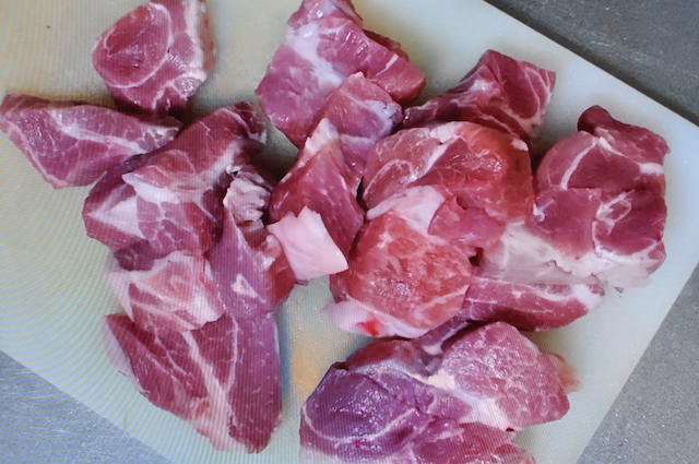 カレーの具材に使う豚肉を切る